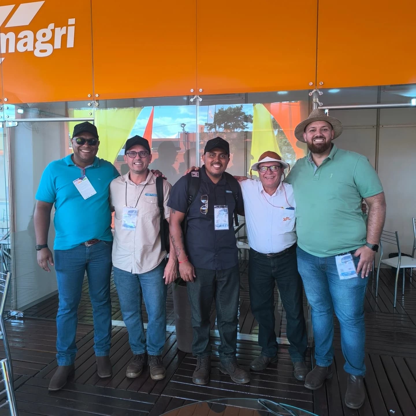 Grupo de cinco pessoas reunidas no estande da Incomagri durante a Agrishow.