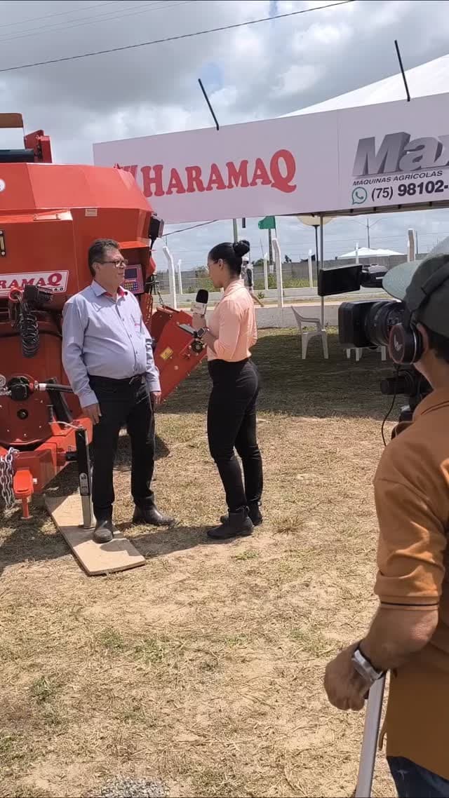 José Escoura sendo entrevistado por repórter de TV ao lado de um misturador Haramaq no estande da feira.